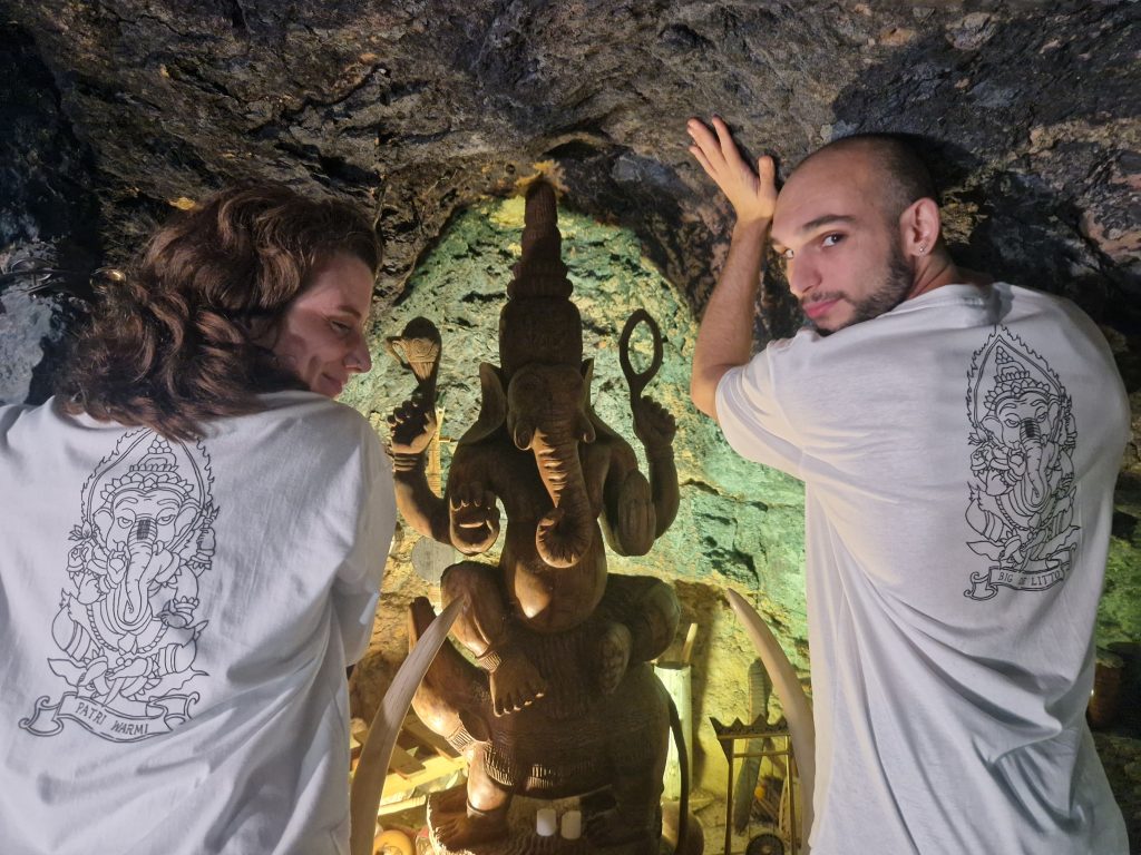 Patricia y Galo de espaldas mostrando la impresión de su camiseta que muestra un Ganesh muy similar al que encontramos en la cueva de Stone Cage Records.